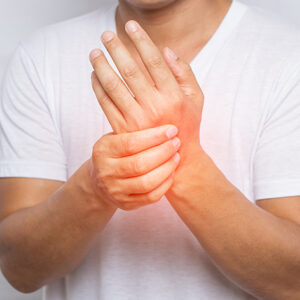 close up of man suffering from pain in hand or wrist